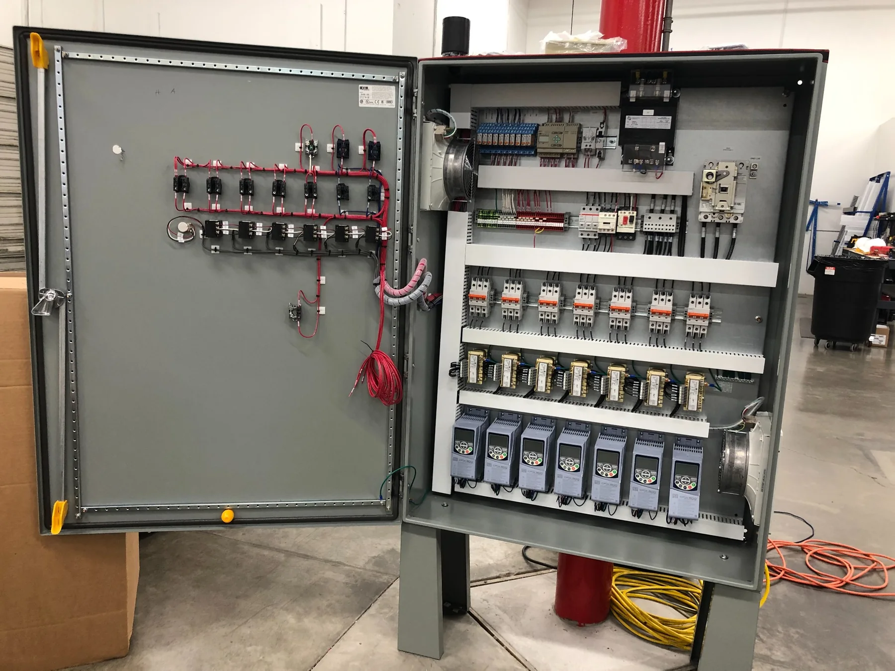 Industrial control cabinet with VFDs, relays, breakers, and terminal wiring